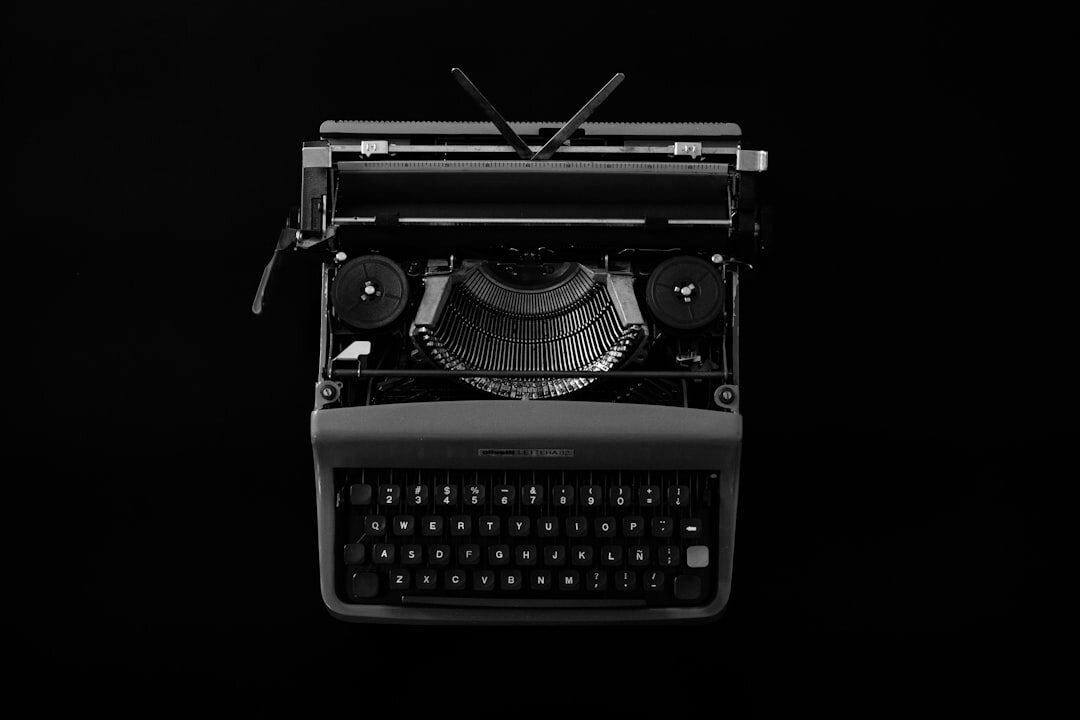 Vintage typewriter with manuscript pages and coffee cup on wooden desk